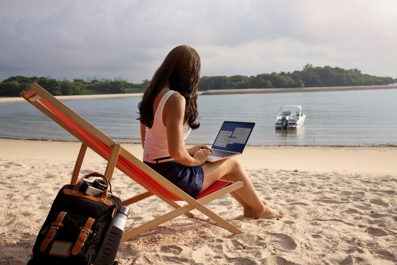 Une femme sur un ordinateur sur la plage