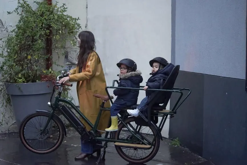 Femme et enfants sur un vélo cargo par temps d’hiver