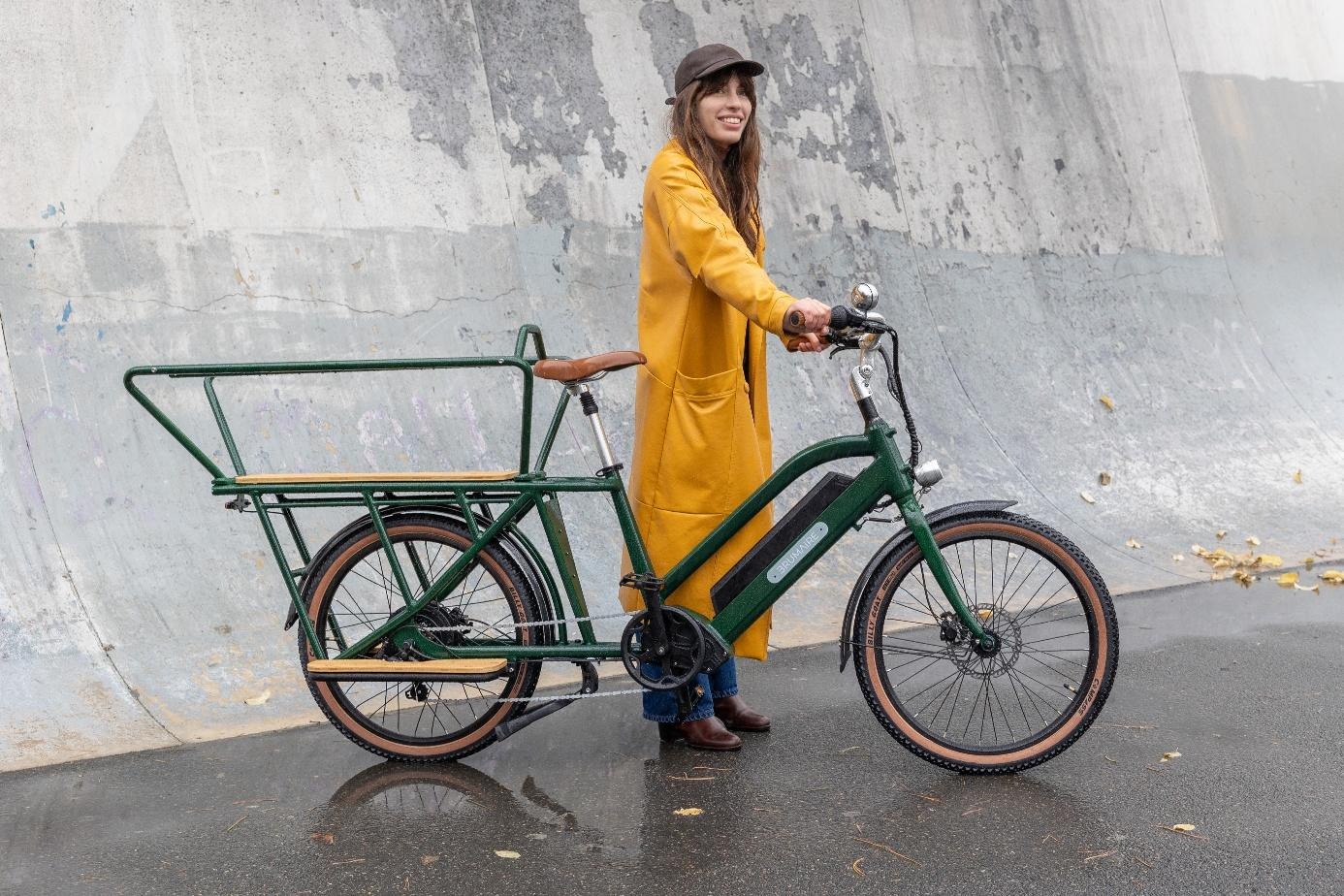 Une femme debout près d'un vélo Nebula vert