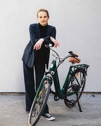 Une femme qui se tient contre le vélo de ville Folio de Brumaire