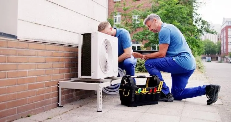 Deux hommes qui installent une PAC