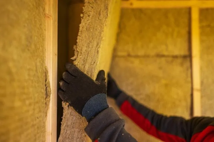 Une personne qui pose des plaques d'isolant