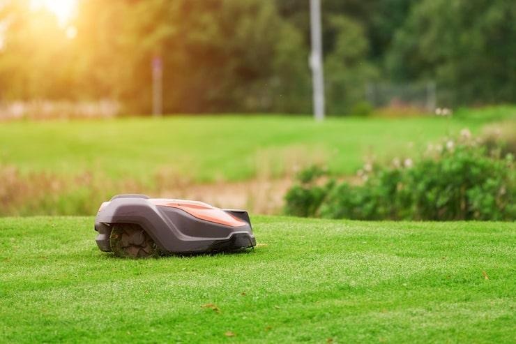 Un robot tondeuse autonome qui tond une pelouse