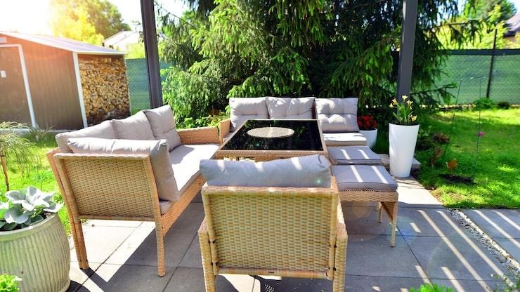 Un salon de jardin en rotin sous une pergola