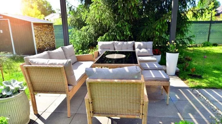 Un salon de jardin en rotin sous une pergola