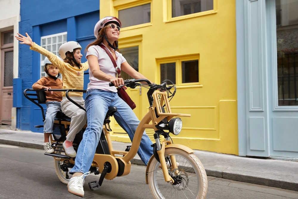 Une femme sur un vélo électrique Gaya avec deux enfants à l'arrière