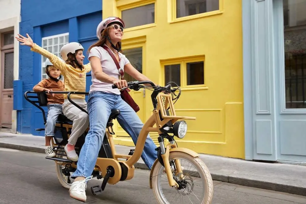 Une femme sur un vélo électrique Gaya avec deux enfants à l'arrière