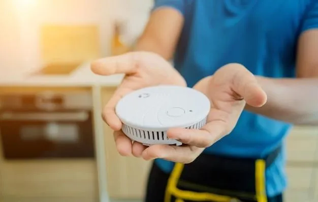 Un homme qui tient dans sa main un détecteur de coupure automatique