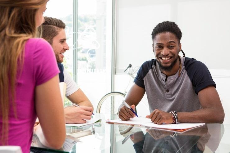 Un homme qui signe un contrat d'assurance pour vélo cargo face à deux personnes