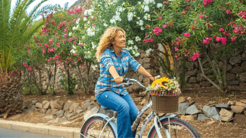 Femme qui fait du vélo et qui est heureuse.