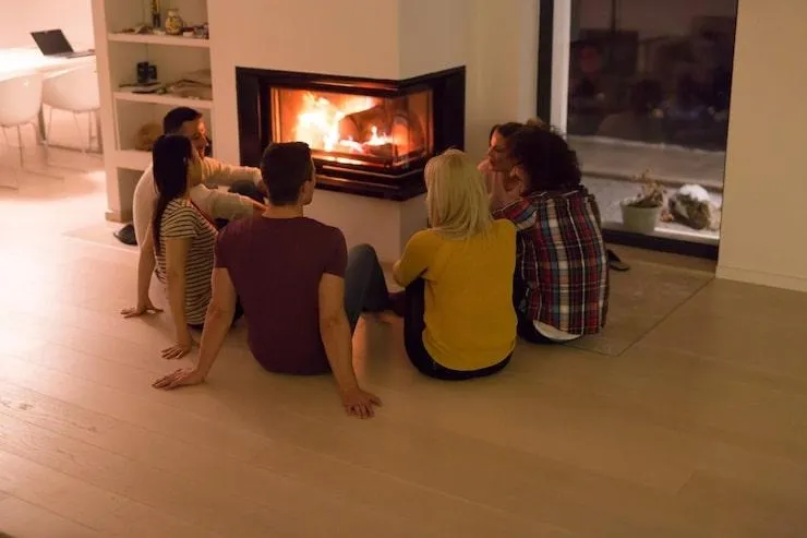 Un groupe de personne devant une poêle à chauffage
