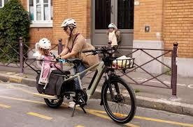 Une femme qui attache une petite fille à l'arrière d'un vélo Nebula de Brumaire