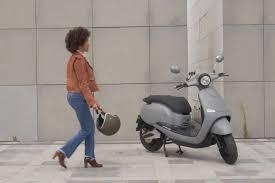 Une femme qui s'approche d'un Scooter électrique de Brumaire