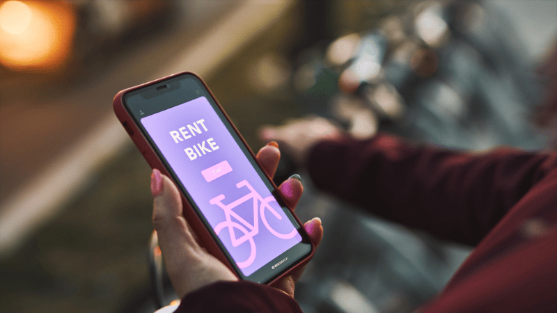Une personne regarde un manuel sur son téléphone à côté d’un vélo électrique.