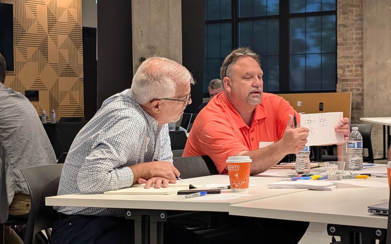 Two engineers discussing product development research ideas and insights during a workshop session