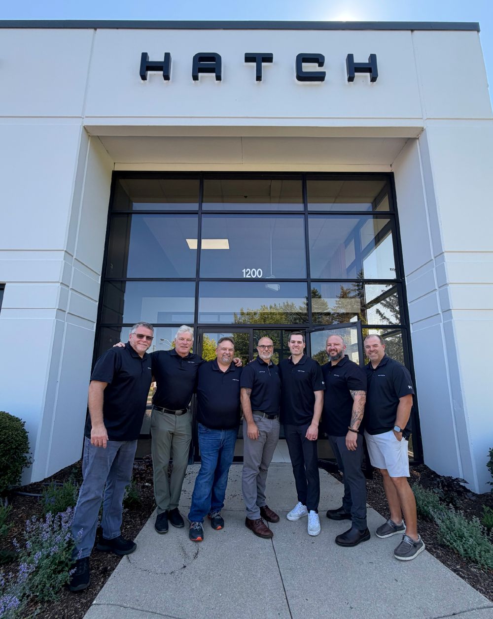 Hatch Product Development & Contract Manufacturing leadership team standing at entrance of new facility in Wauconda, IL