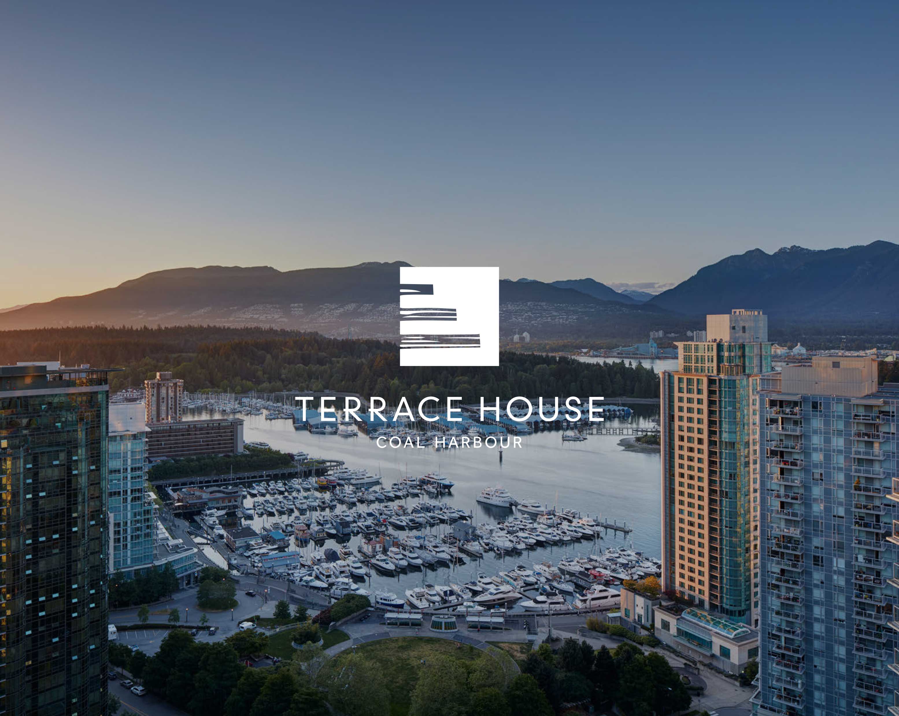Aerial view of a marina filled with boats, surrounded by high-rise buildings and mountains at sunset.