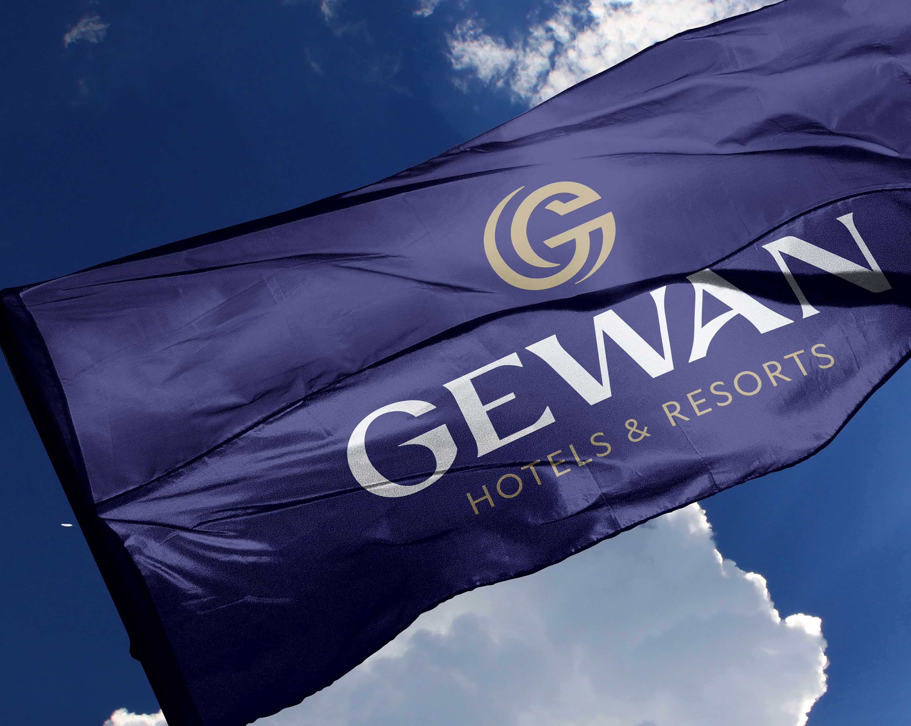 Dark blue flag waving in the sky with the logo and text 'GEWAN Hotels & Resorts'.