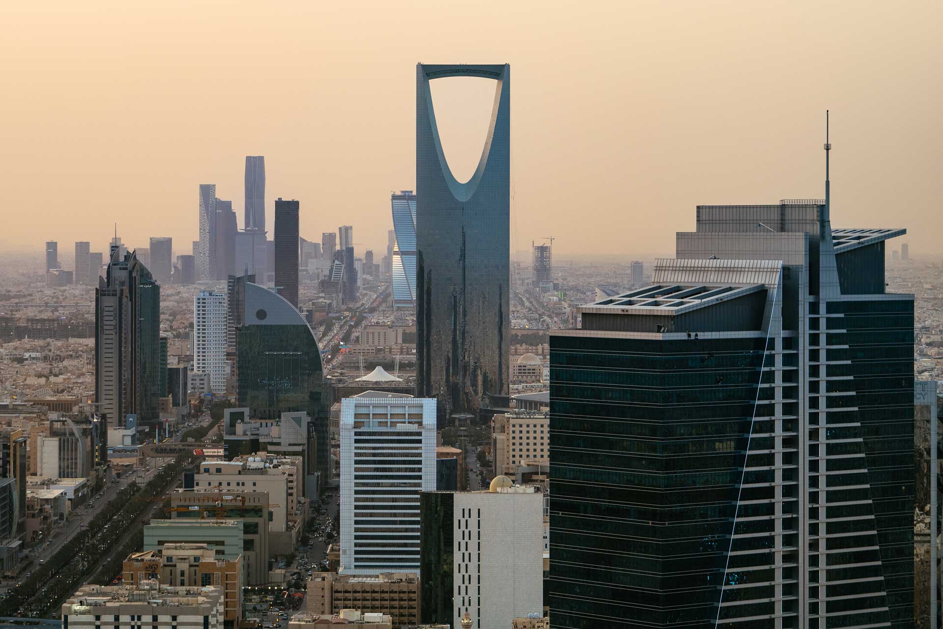 Skyline of Riyadh, Saudi Arabia featuring the prominent Kingdom Centre Tower at dusk.