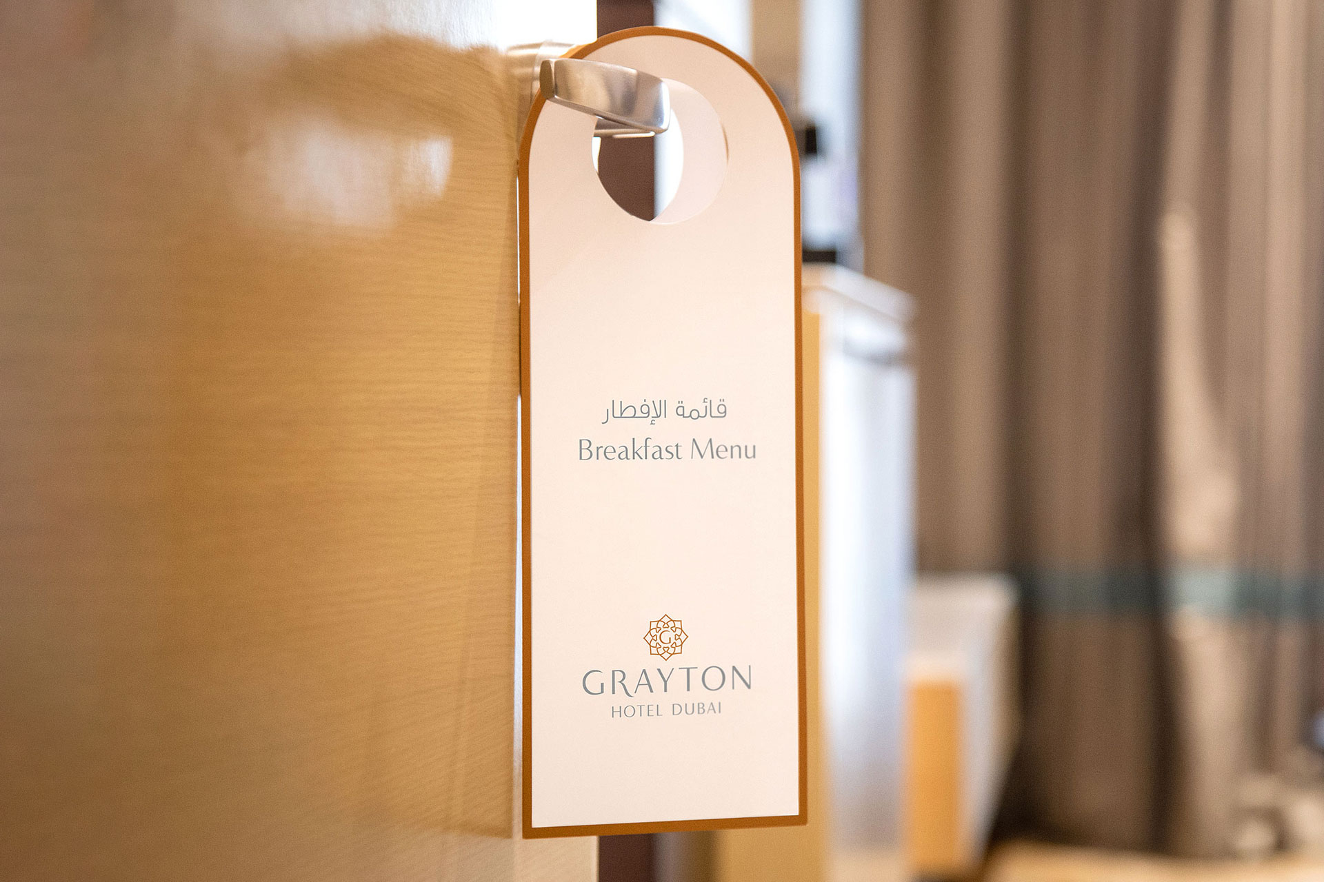Door hanger sign with 'Breakfast Menu' text in English and Arabic, along with the Grayton Hotel Dubai logo.