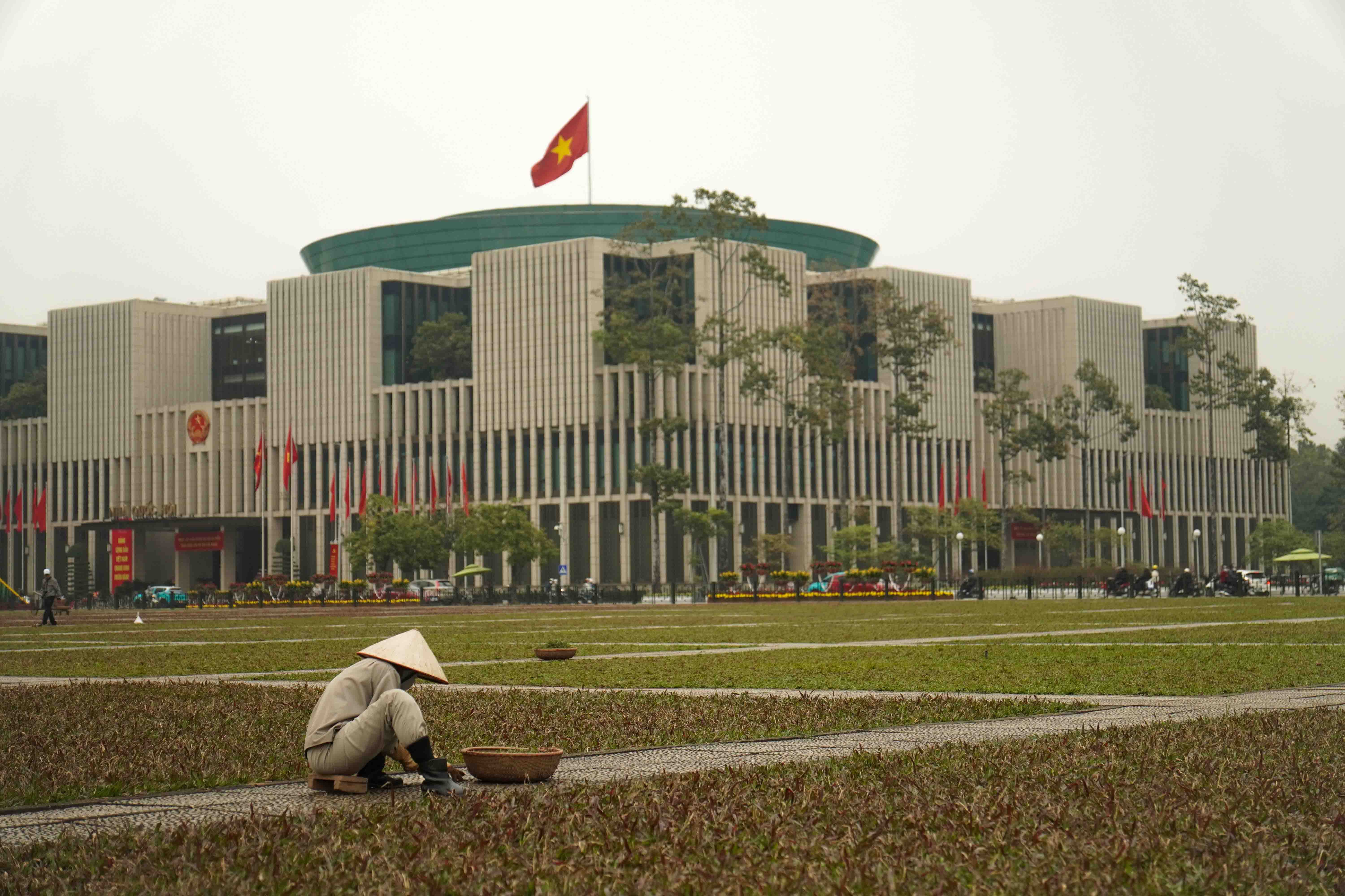 A photo of a field worker in front of Vietnam's NPC.