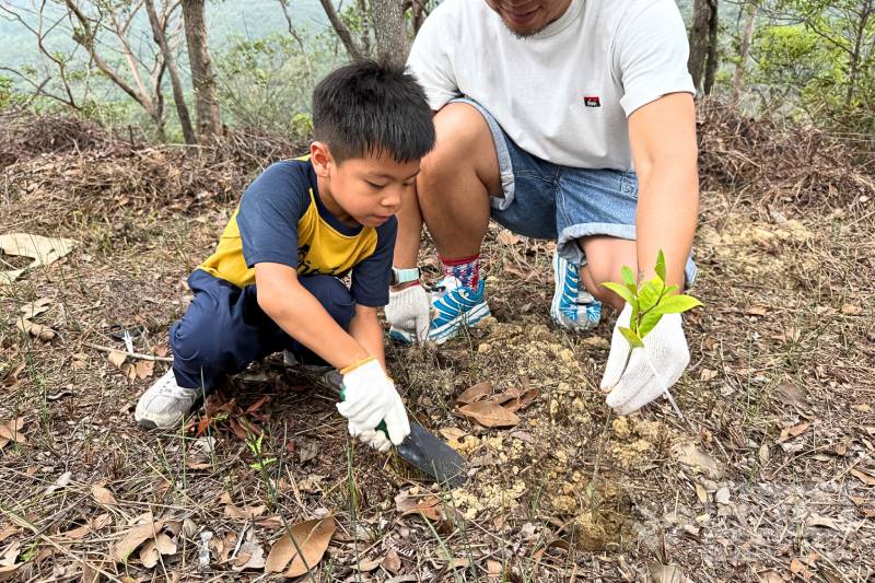 Parent-child family volunteers participate in a tree-planting event
