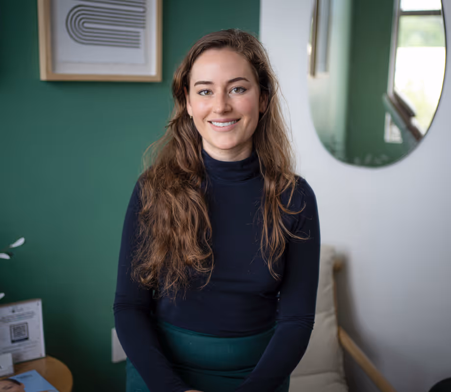 A woman standing in a room with green walls.