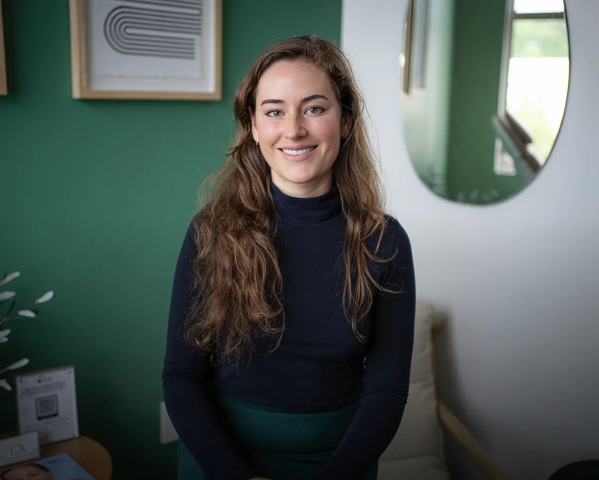 A woman standing in a room with green walls.