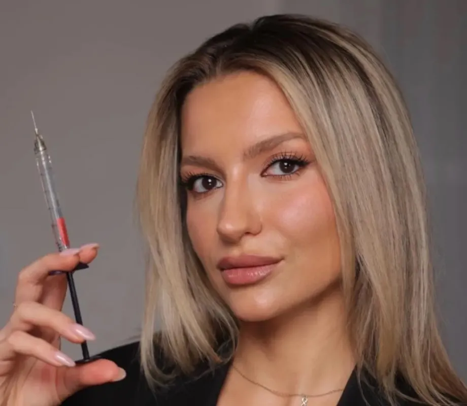 A woman standing in a room with green walls.
