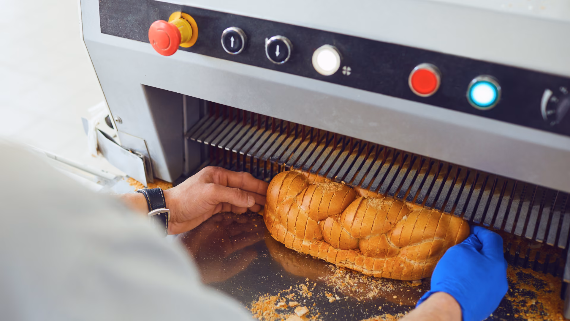 close up of operator using automated bread slicer.