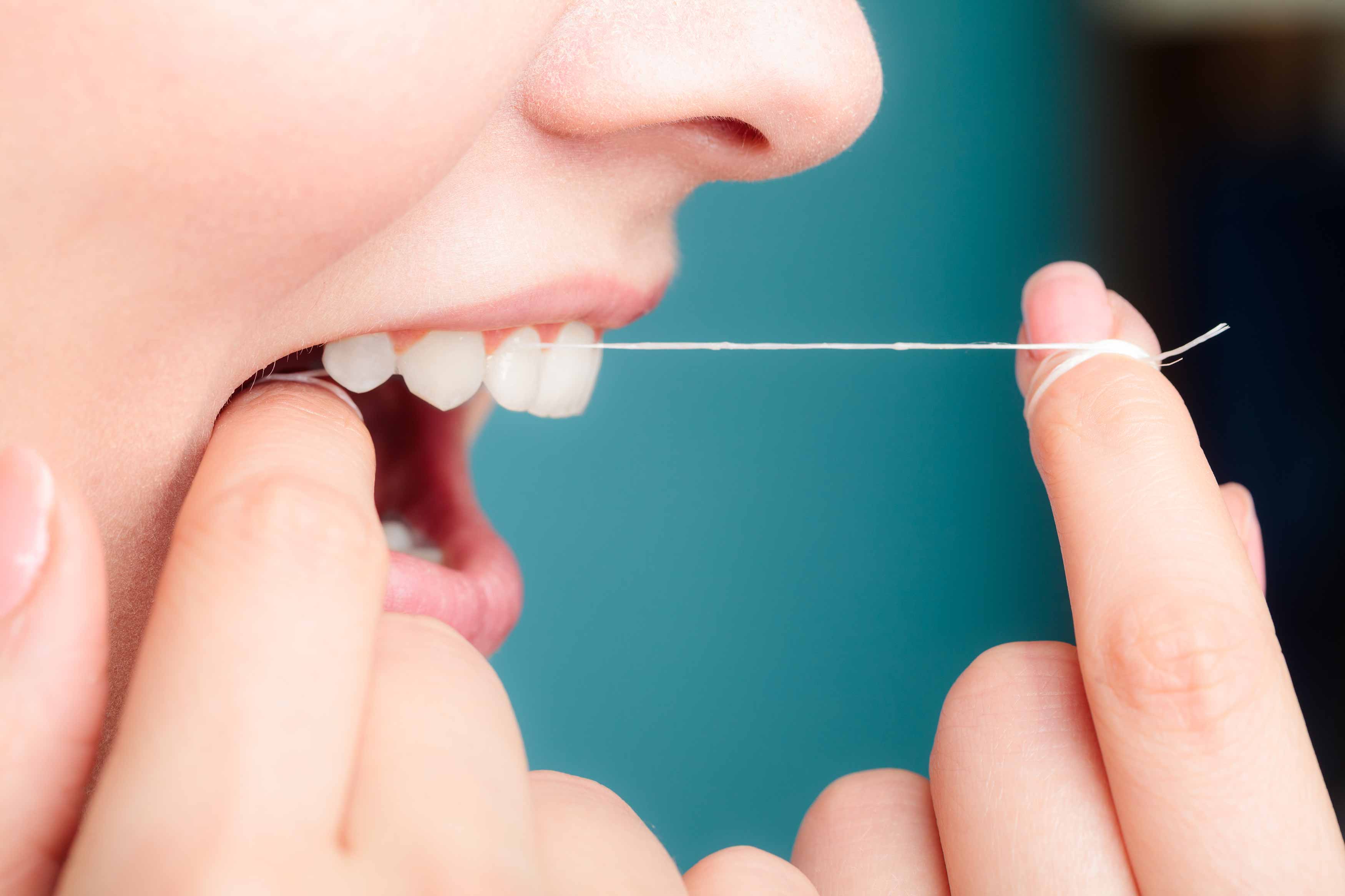 photo of someone flossing their teeth 
