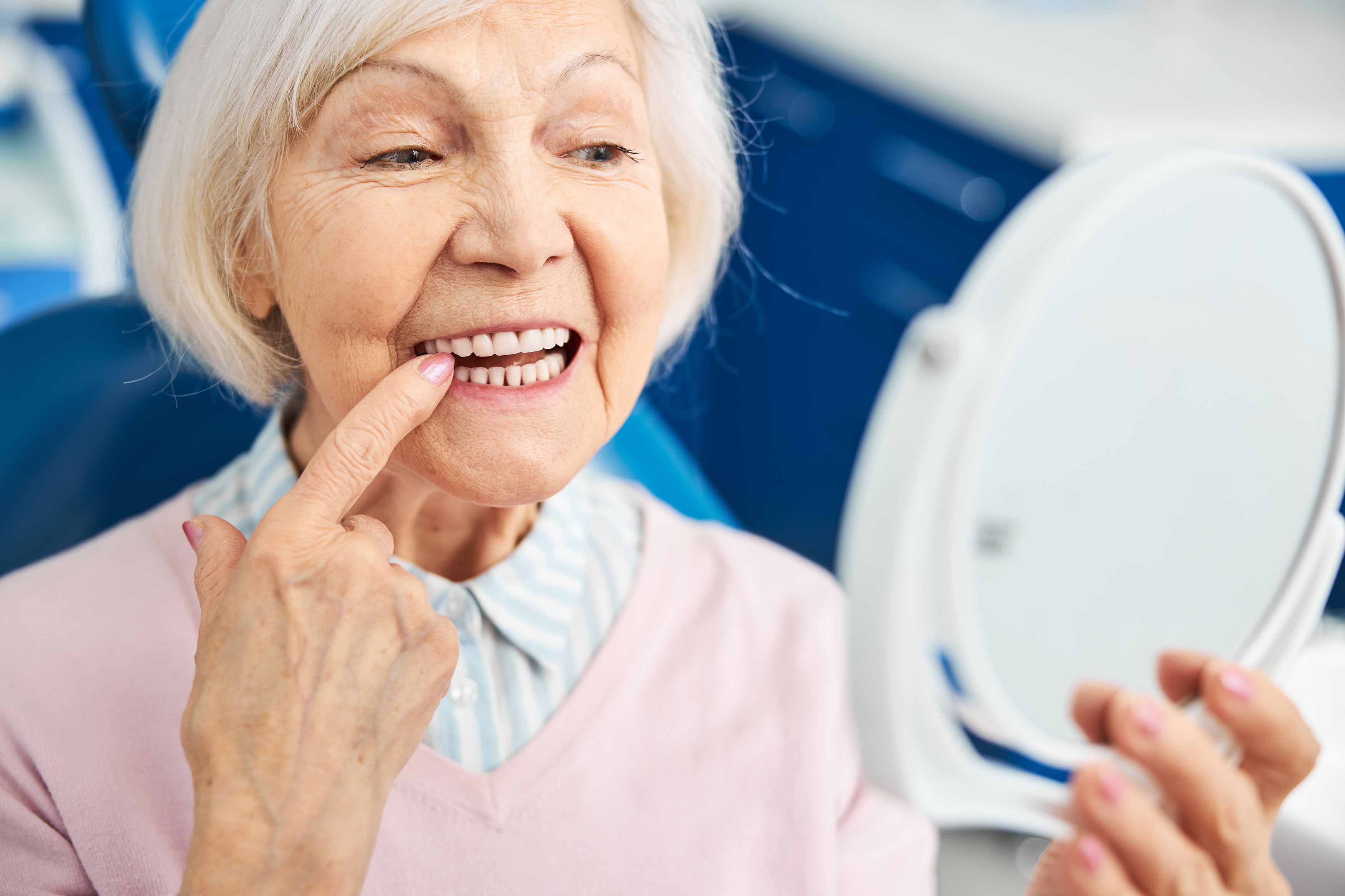 A photo of an elderly female wriggling her lower right tooth