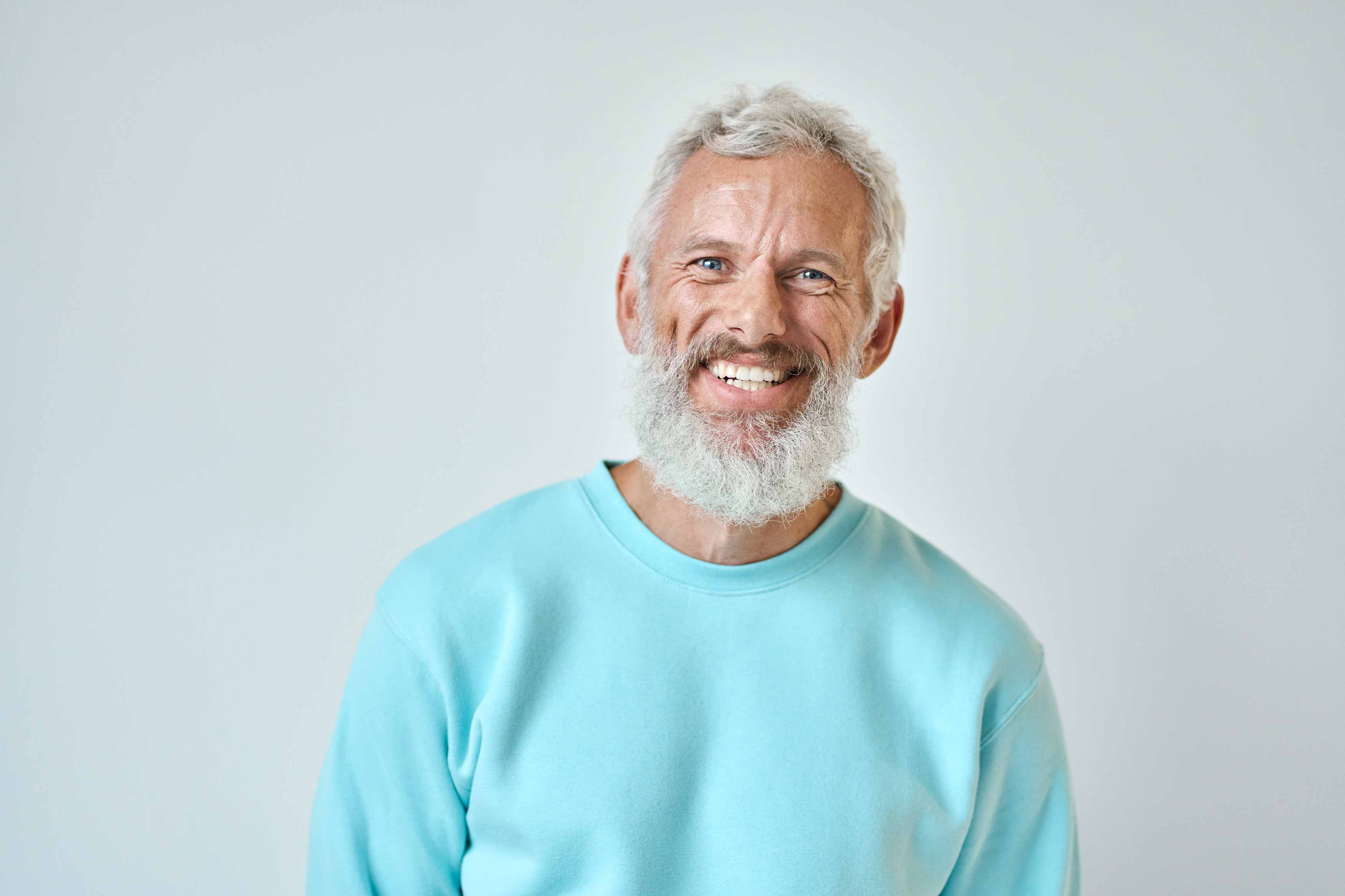 A photo of an elder gentlemen smiling and showing off his teeth