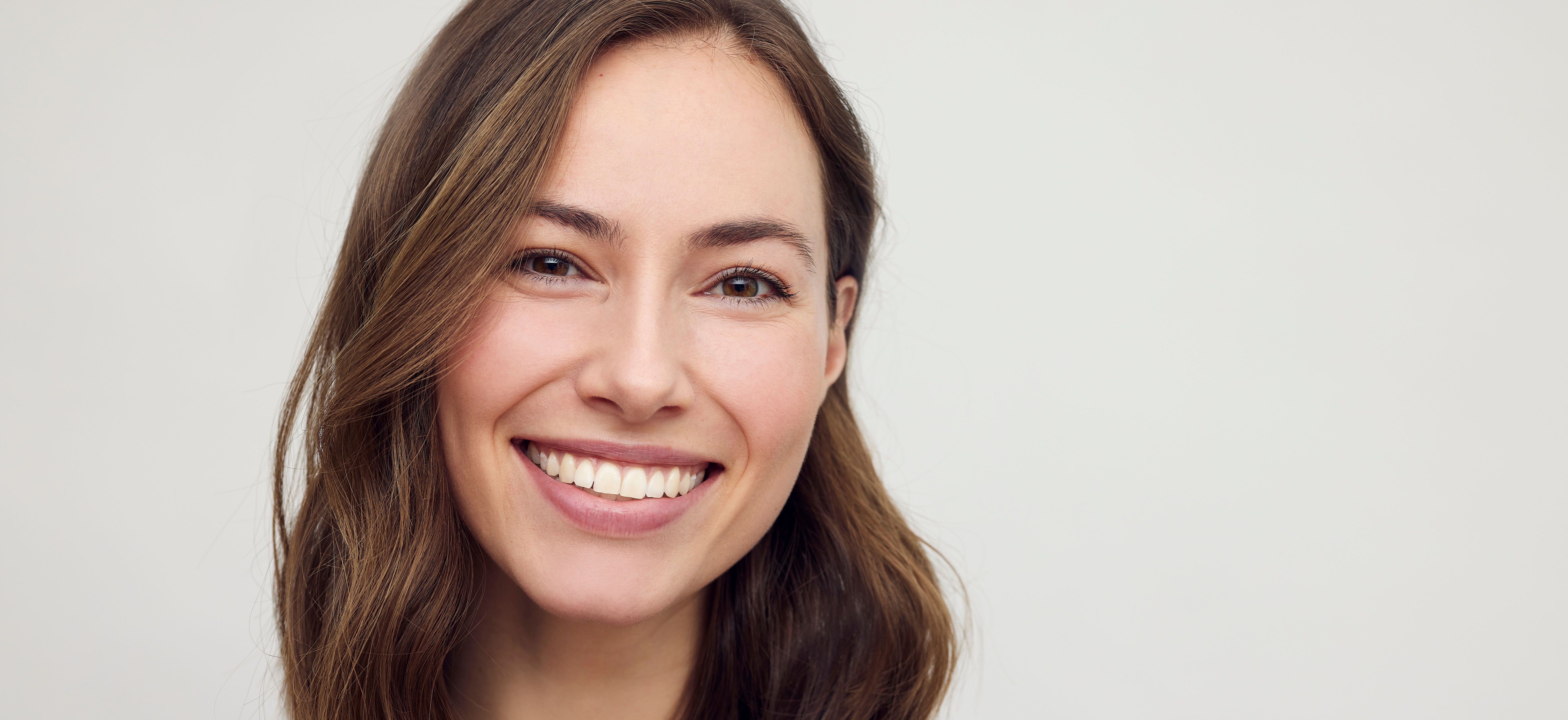 Portrait of a happy brunette caucasian and beautiful woman smiling and standing isolated on white background. Young female girl.