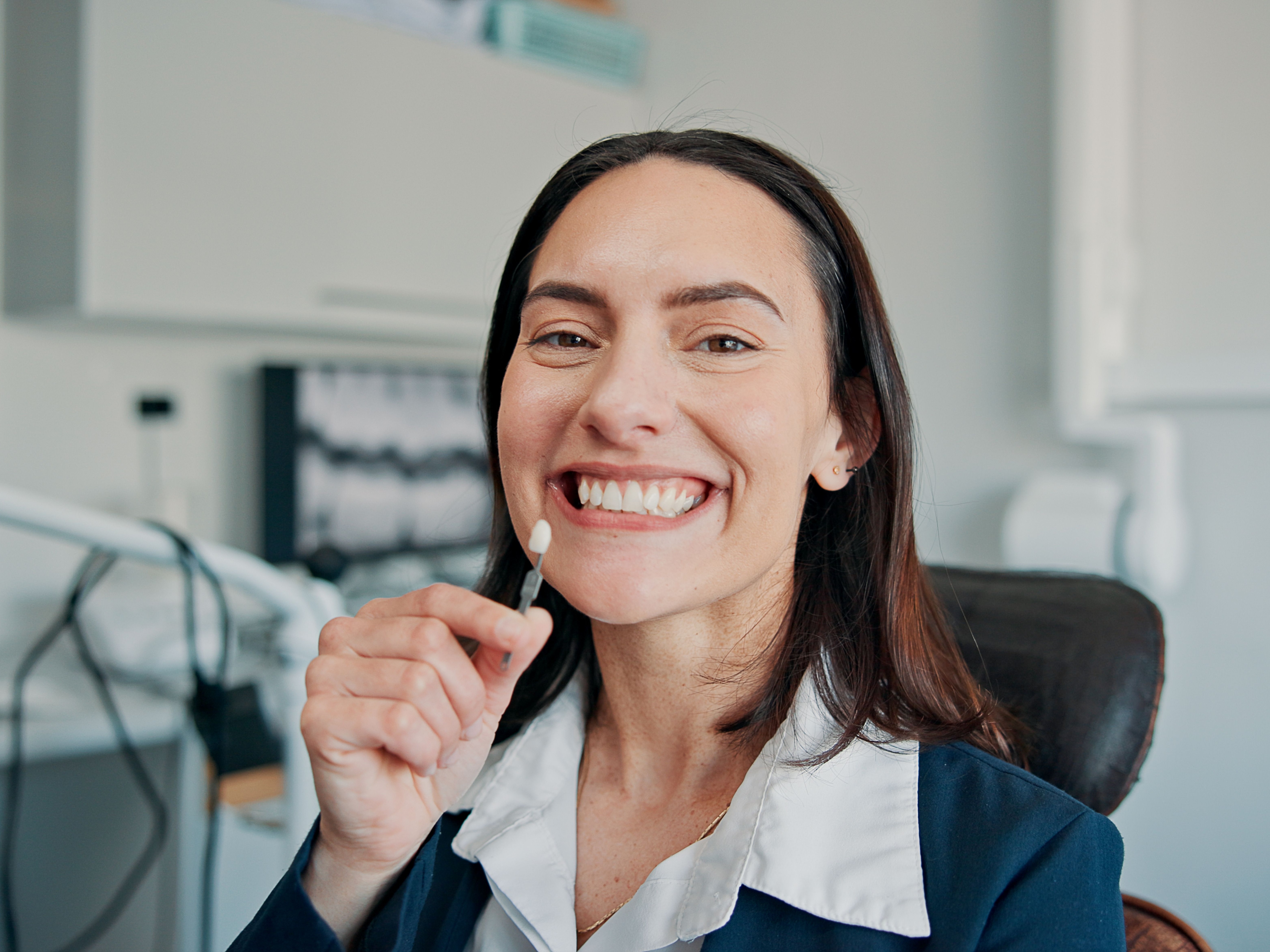 Happy woman, portrait or patient in dental clinic for crown, veneers or medical procedure. Appointment, smile or person with implant in oral exam for dentistry, teeth whitening or cosmetics treatment‍