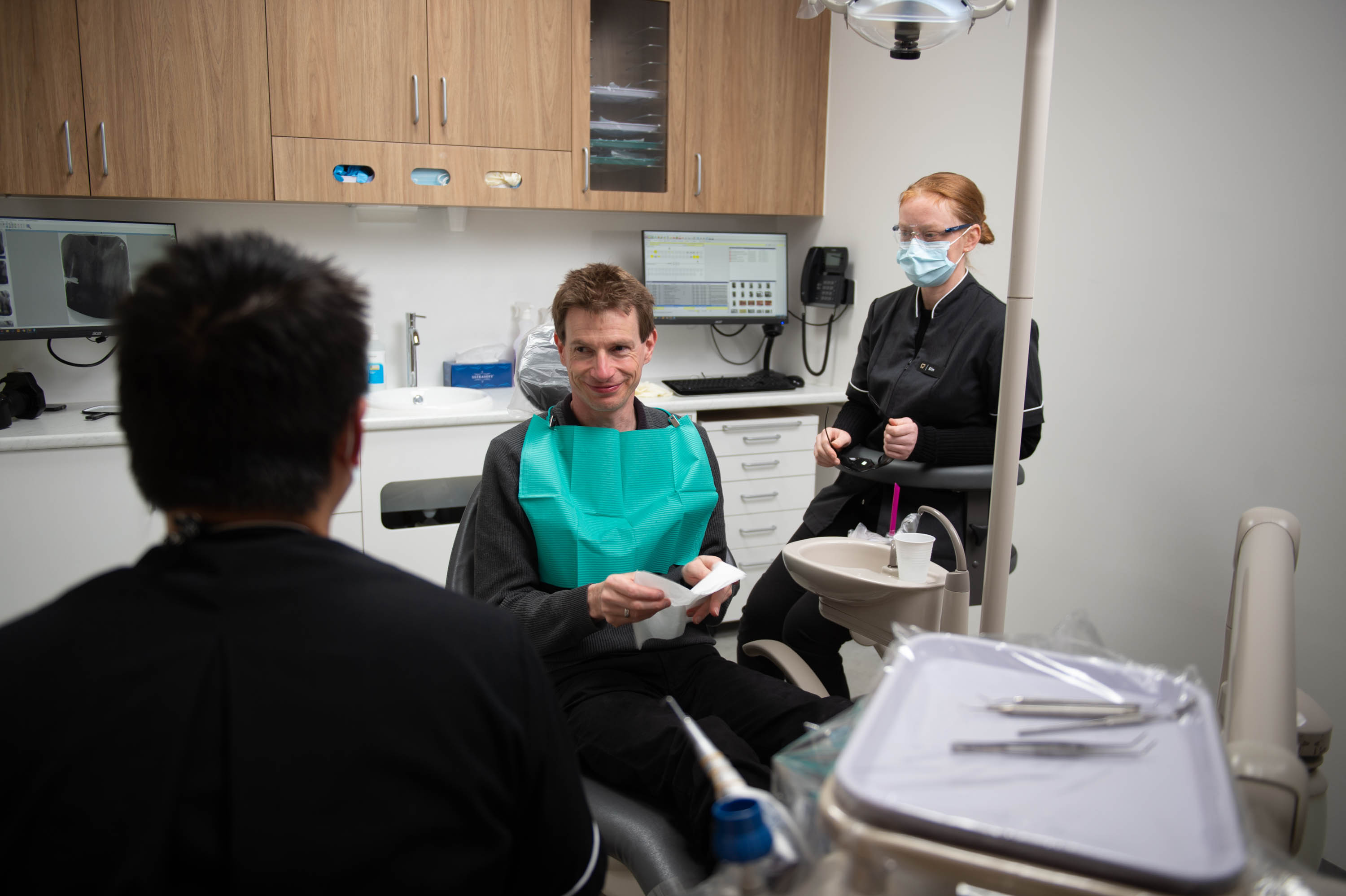 Photo of Erin helping in the background during a patient consultation