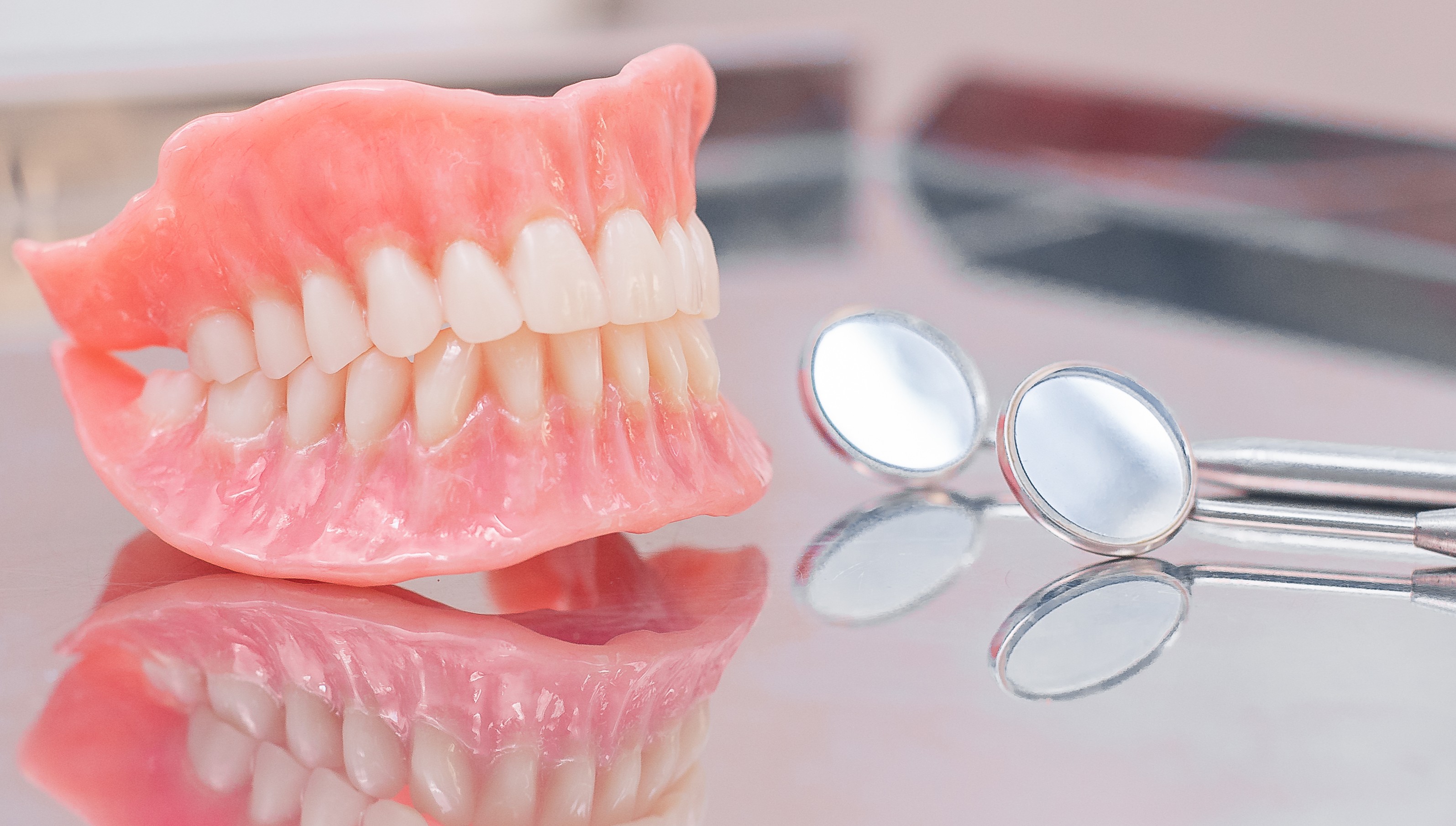 Image of a upper and lower denture and with dental mirrors