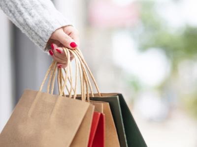 Hand holding paper shopping bags