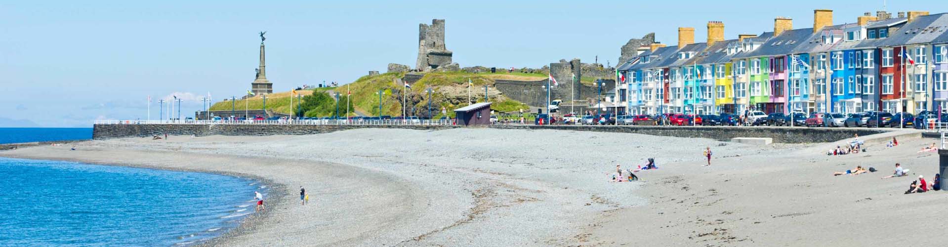 Aberystwyth beach with some people on the sand and stones