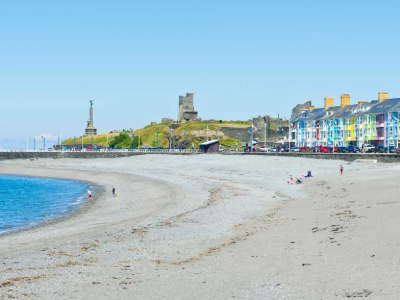 Aberystwyth beach with some people on the sand and stones