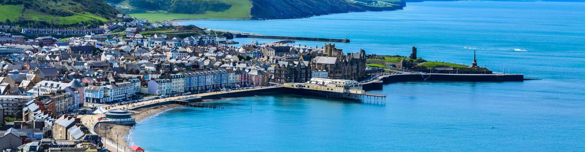 Aerial shot of the Aberystwyth coastline with the sandy beach and blue sea on a sunny day