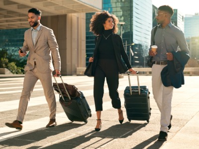 Business men and women walking down a street, on a business trip.