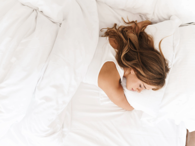 Woman sleeping in hotel bed.