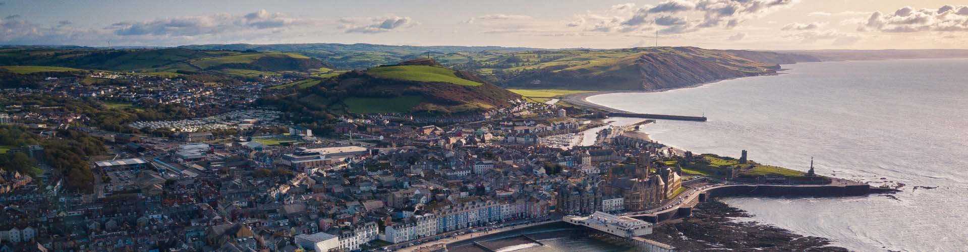 Aerial view of Aberystwyth seafront, promenade and town with Cardigan Bay coastline, Wales
