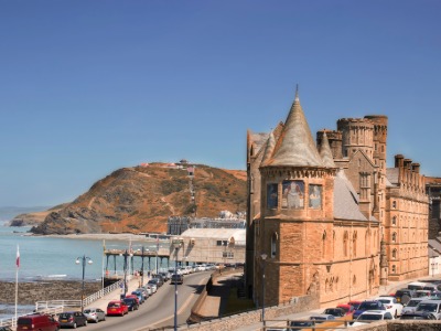 Aberystwyth Old College castle building with Constitution Hill and Cardigan Bay coastline on a sunny