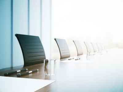 Office chairs lined up along the side of a meeting table