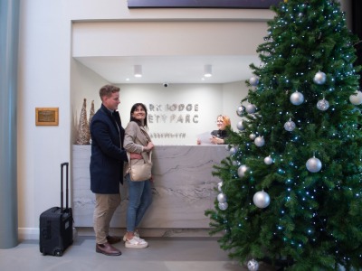 Guests arriving at Park Lodge Hotel Aberystwyth reception with Christmas tree decorations.