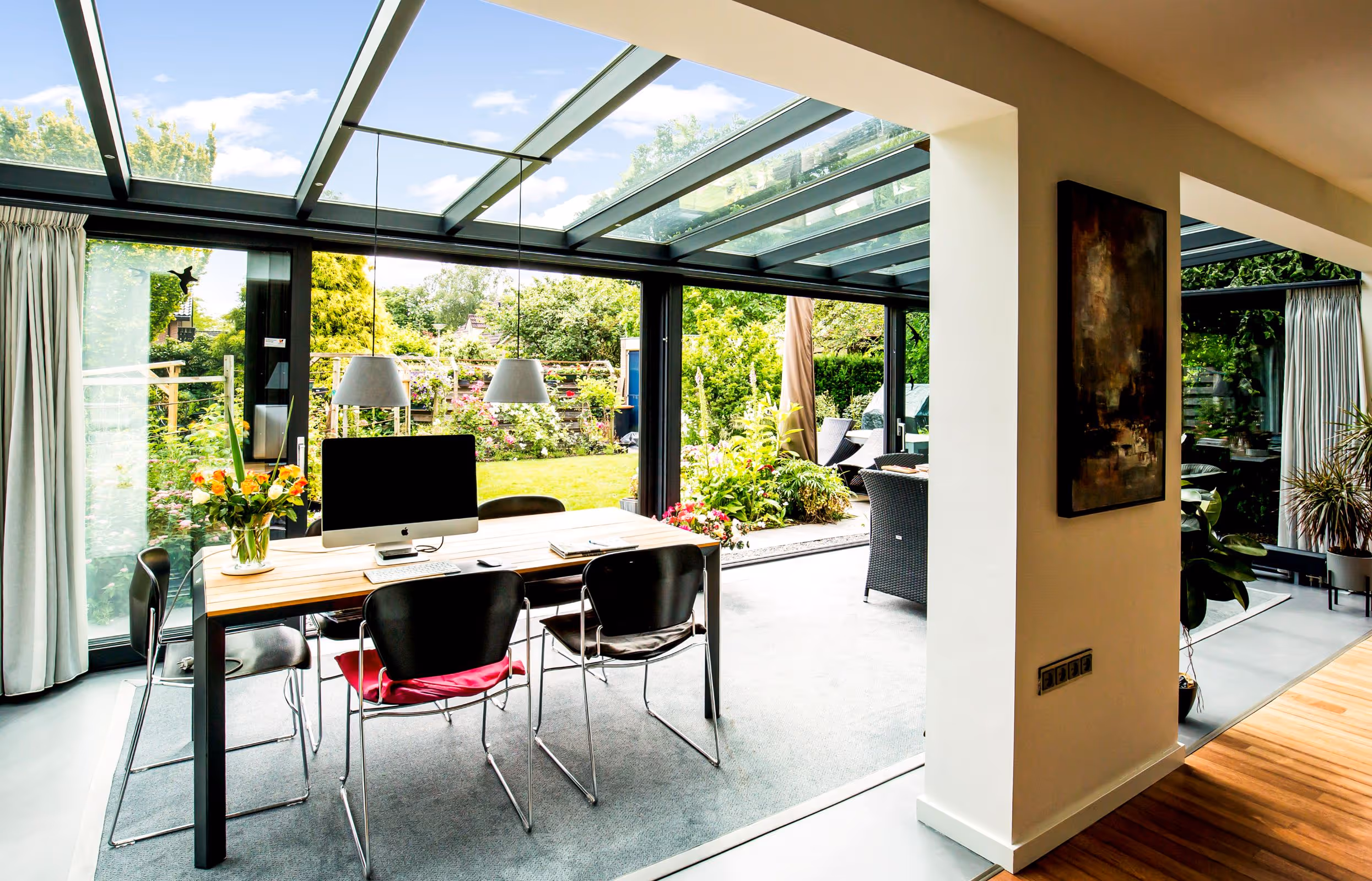 Luxe tuinkamer met glazen schuifpuien, verbonden met de tuin en ingericht als leefruimte