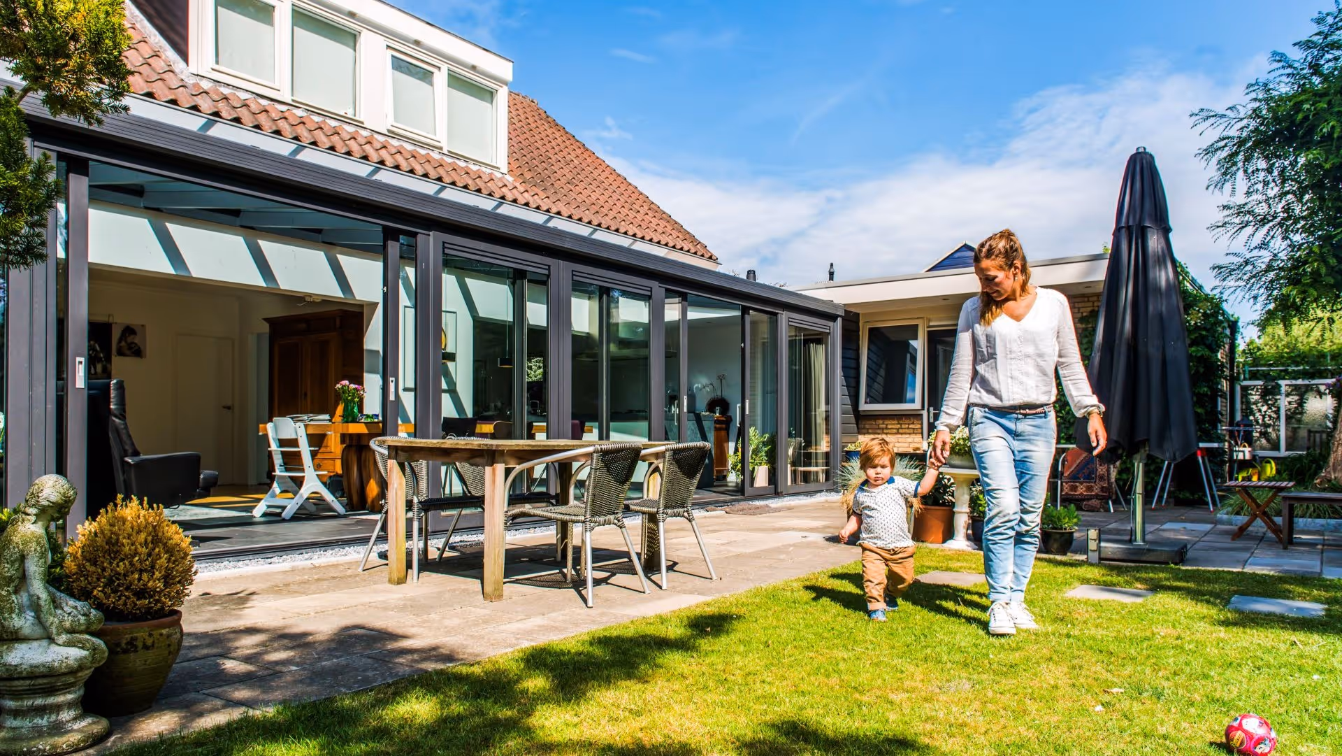 Moderne serre aanbouw met grote glaspartijen en directe toegang tot de tuin