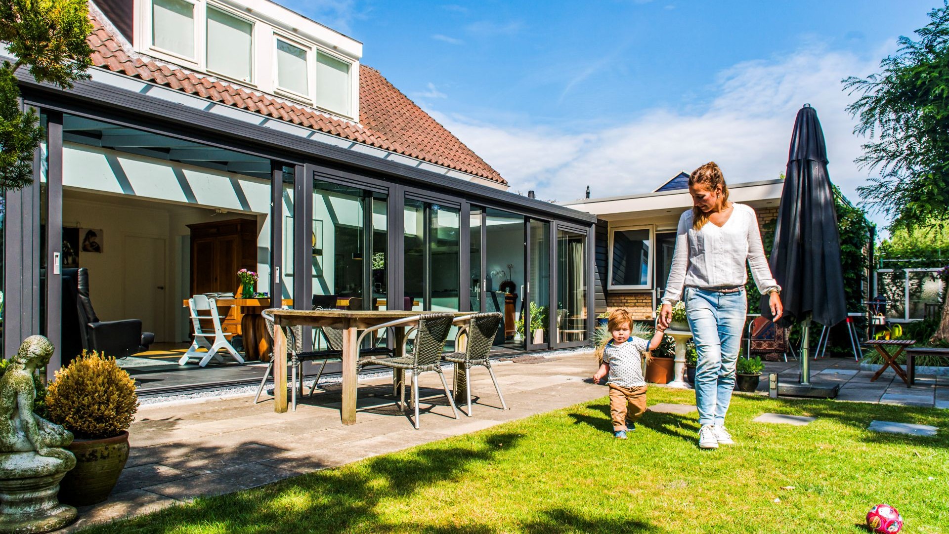 Moderne serre aanbouw met grote glaspartijen en directe toegang tot de tuin